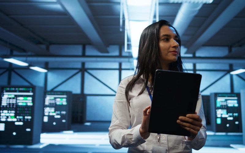 Admin in data center monitoring security threats with tablet